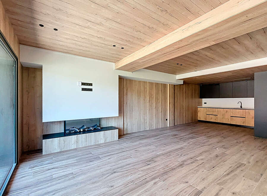 Stunning open-plan living space with a modern fireplace and sleek kitchen.