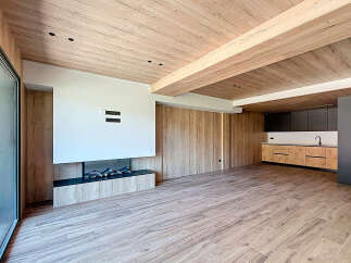 Stunning open-plan living space with a modern fireplace and sleek kitchen.