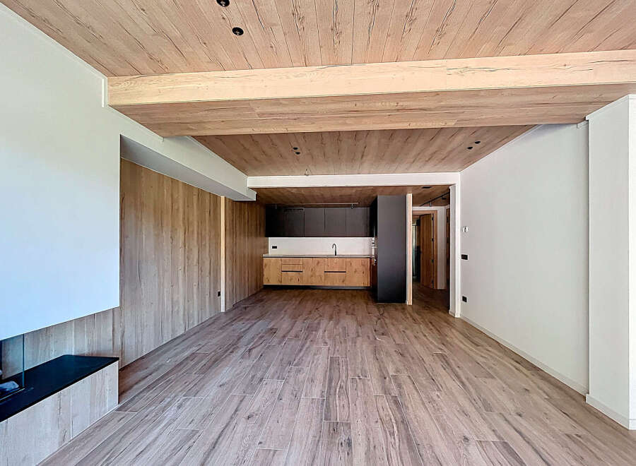 Stunning open-plan living space with wood beam ceilings and modern kitchen.