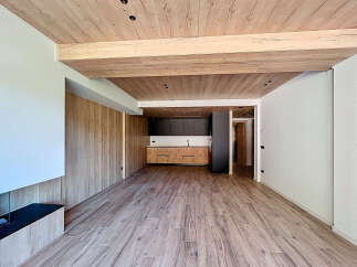 Stunning open-plan living space with wood beam ceilings and modern kitchen.
