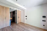 This stunning property boasts a spacious bedroom with sleek wooden closets and a modern glass partition.