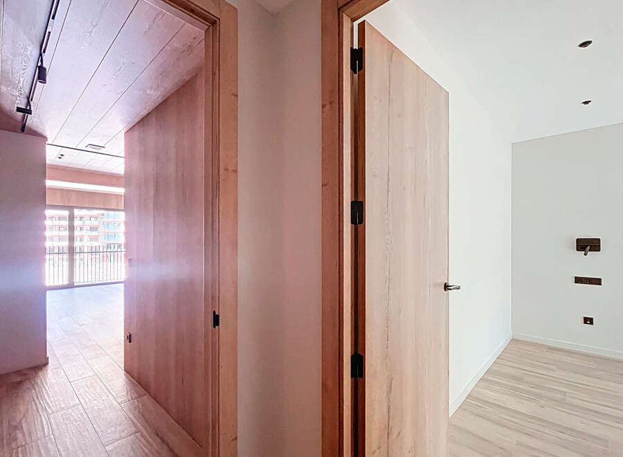 This stunning property boasts two spacious rooms with sleek wooden doors and modern light fixtures.