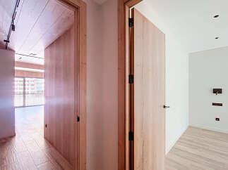 This stunning property boasts two spacious rooms with sleek wooden doors and modern light fixtures.