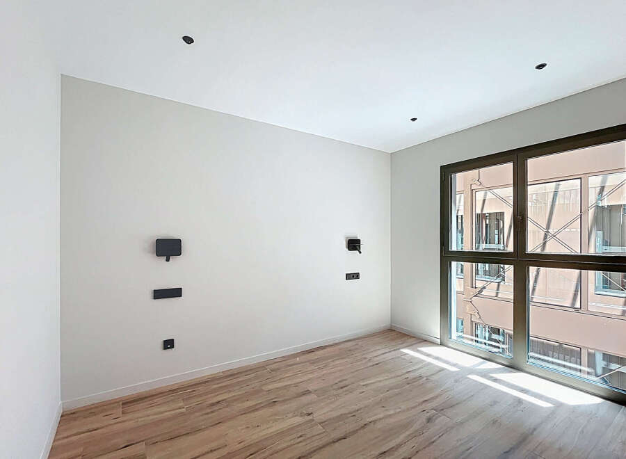 Bright and airy room with large window offering ample natural light.
