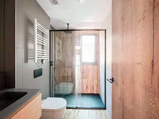 Modern bathroom with a walk-in shower, sleek fixtures, and wood-look tile.