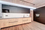 This modern kitchen boasts sleek, dark cabinetry and a stylish design.