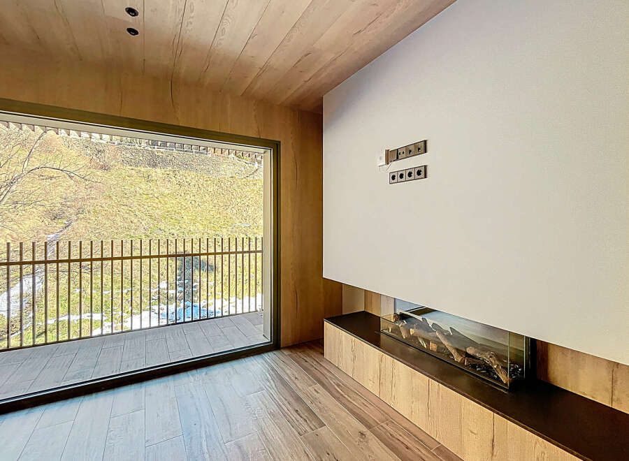 Experience luxury living in this stunning property with a modern fireplace and expansive windows.