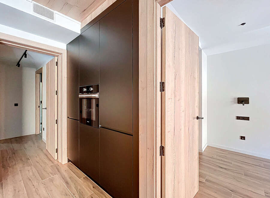 This modern kitchen boasts sleek, dark cabinetry and a built-in oven, offering a sophisticated and functional space.