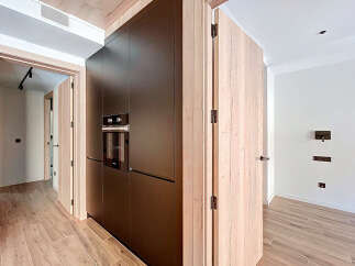 This modern kitchen boasts sleek, dark cabinetry and a built-in oven, offering a sophisticated and functional space.