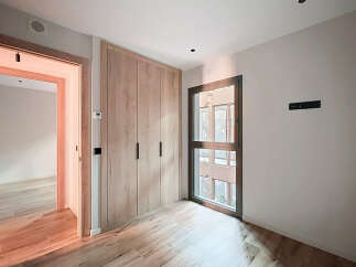 Discover the elegance of this modern space, featuring a beautifully designed built-in wardrobe with sleek black handles.