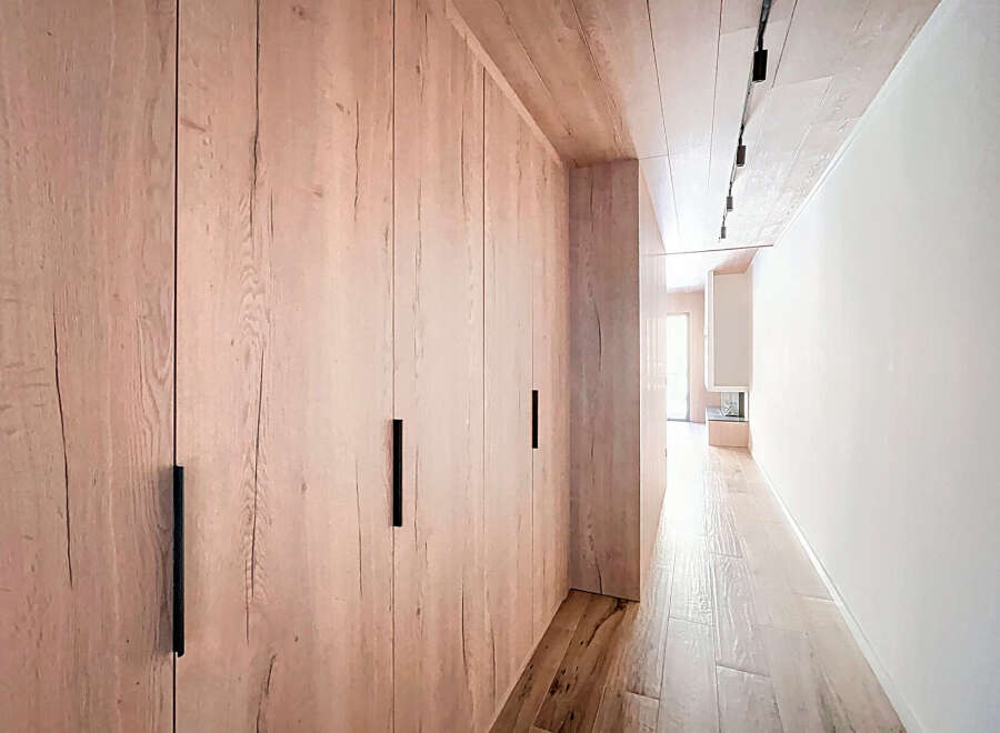 This stunning property features a beautifully designed hallway with custom wooden cabinetry.
