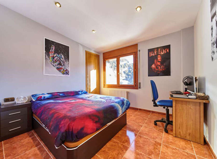 Cozy bedroom with mountain views and a vibrant duvet.