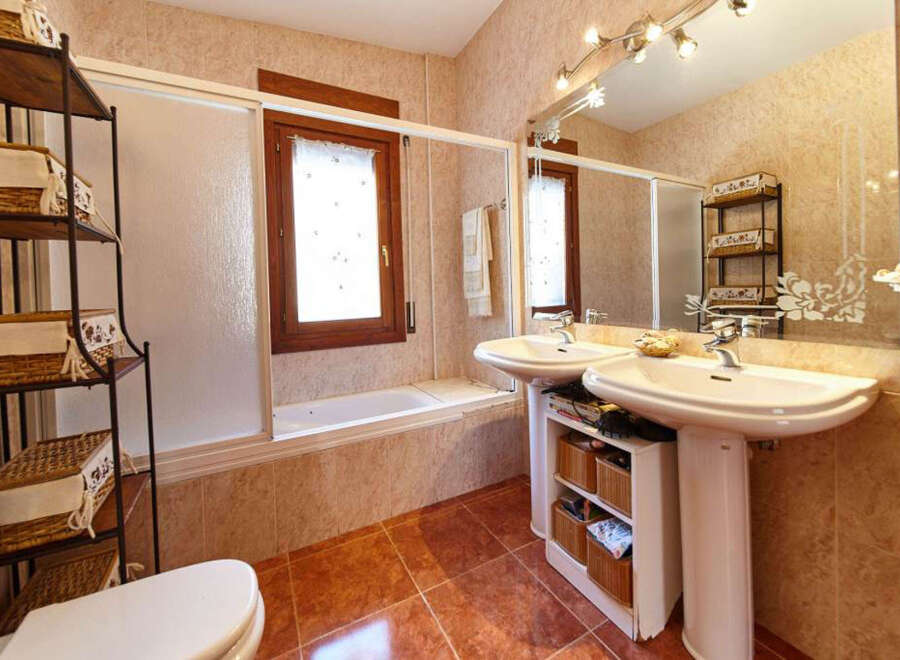 This stunning bathroom boasts a spacious layout with dual sinks, a relaxing bathtub, and ample storage.