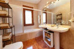 This stunning bathroom boasts a spacious layout with dual sinks, a relaxing bathtub, and ample storage.