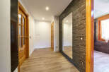 This stunning hallway boasts a modern design with sleek flooring and a beautiful stone accent wall.