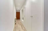 This stunning hallway boasts built-in white wardrobes, offering ample storage space.