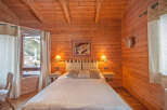Cozy wooden cabin bedroom with mountain views.