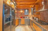 This stunning kitchen boasts a unique blend of modern and rustic design, featuring sleek black appliances and rich wood cabinetry.