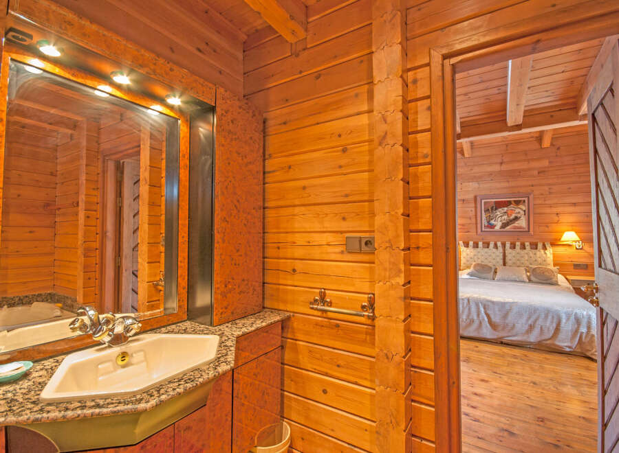 This stunning log cabin boasts a luxurious bathroom with granite countertops and a modern sink.