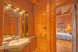 This stunning log cabin boasts a luxurious bathroom with granite countertops and a modern sink.