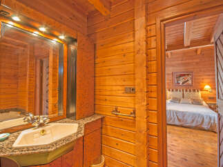 This stunning log cabin boasts a luxurious bathroom with granite countertops and a modern sink.