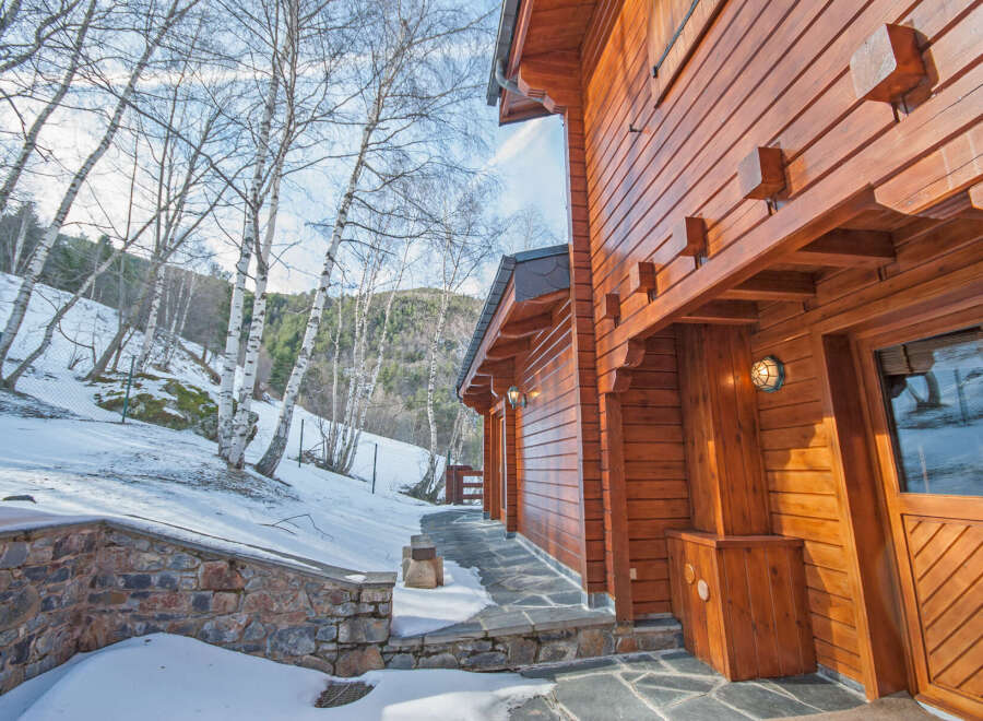 This stunning log cabin boasts a beautiful wooden exterior, perfect for a cozy winter getaway.
