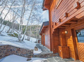 This stunning log cabin boasts a beautiful wooden exterior, perfect for a cozy winter getaway.