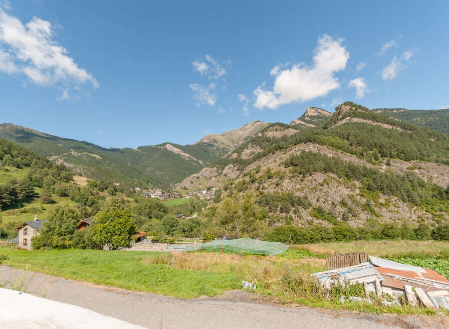 Mountain view home with large green lawn and garden.