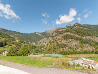 Mountain view home with large green lawn and garden.