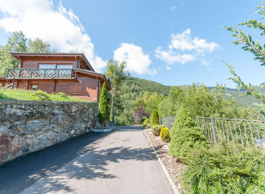 Mountain view chalet with private driveway and landscaped gardens.