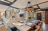 This stunning mountain home boasts an open-concept living area with floor-to-ceiling windows offering breathtaking views, a cozy fireplace, and a spacious dining area perfect for entertaining.