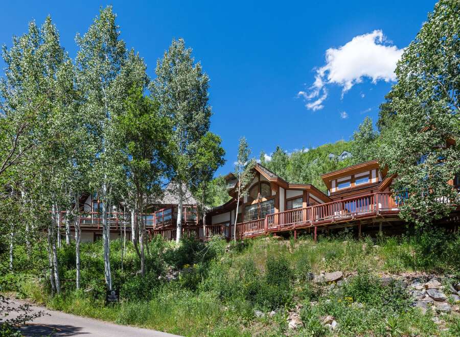Luxury mountain homes nestled in a lush aspen grove, offering stunning views and private decks.