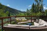 Enjoy breathtaking mountain views from this luxurious deck, complete with comfortable wicker furniture and plush cushions.
