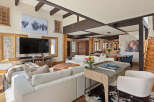 This stunning vacation rental boasts an open-concept living area with a cozy sectional sofa, a large flat-screen TV, and a beautiful wooden coffee table.