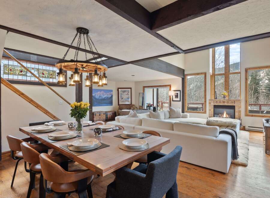 This stunning mountain home boasts an open floor plan with hardwood floors, a cozy fireplace, and large windows offering breathtaking views.