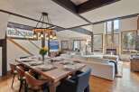 This stunning mountain home boasts an open floor plan with hardwood floors, a cozy fireplace, and large windows offering breathtaking views.