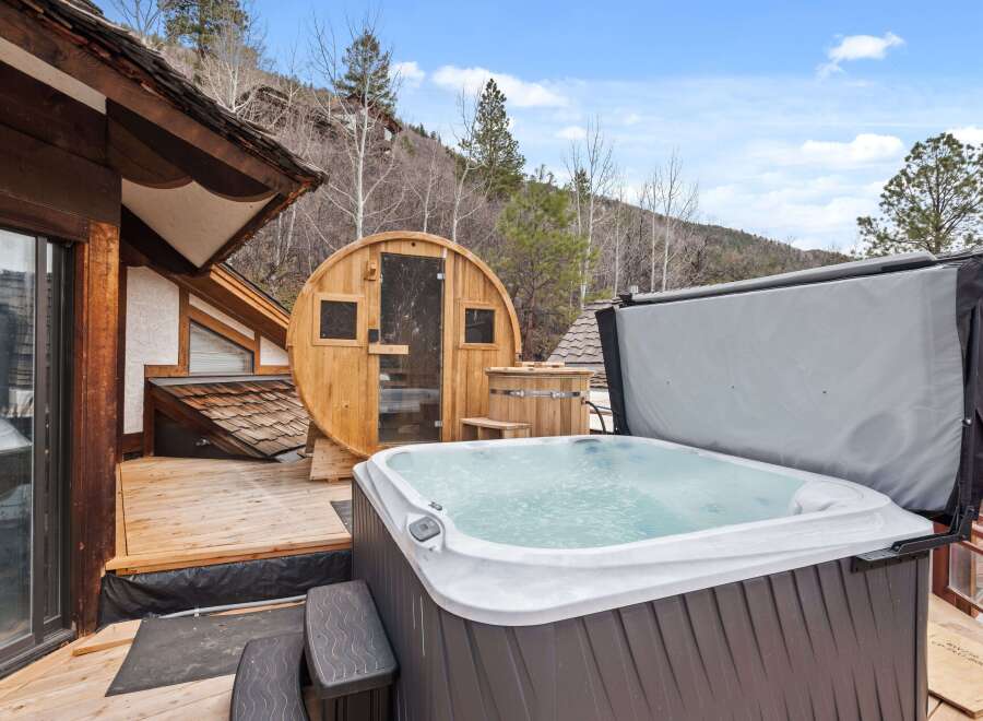 Luxury mountain retreat with a private hot tub and sauna on a spacious deck.