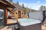 Luxury mountain retreat with a private hot tub and sauna on a spacious deck.