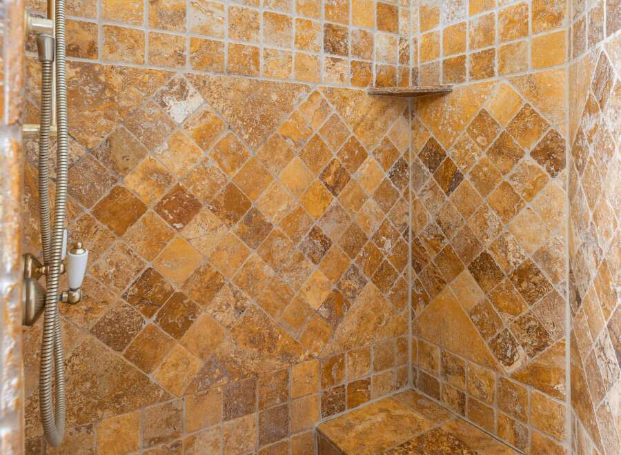 This luxurious bathroom boasts a stunning tiled shower with a built-in seat, perfect for relaxation.