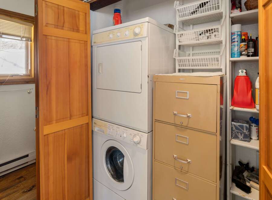 This cozy laundry room features a stackable washer and dryer set, perfect for a small space.