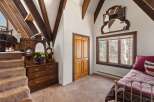 This charming bedroom boasts a cozy atmosphere with its unique sloped ceilings and exposed wooden beams.