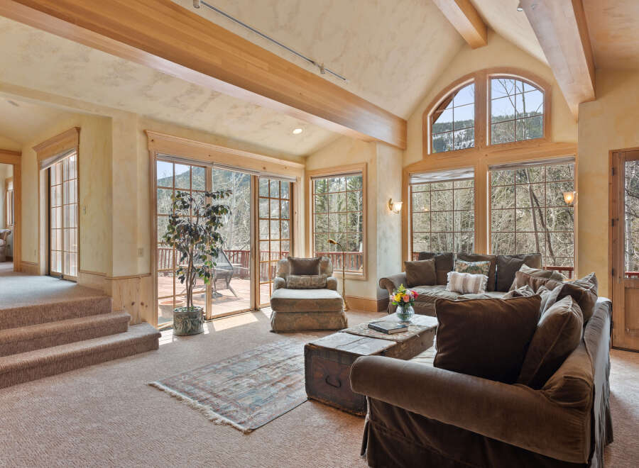 This stunning mountain home boasts a spacious, open-concept living area with vaulted ceilings and large windows offering breathtaking views.