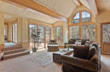 This stunning mountain home boasts a spacious, open-concept living area with vaulted ceilings and large windows offering breathtaking views.