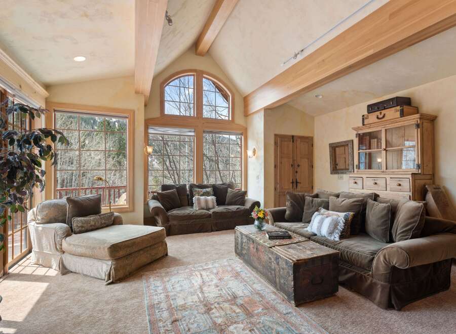 This stunning living room boasts a vaulted ceiling with exposed wooden beams, creating an open and airy atmosphere.