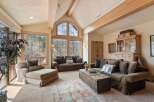 This stunning living room boasts a vaulted ceiling with exposed wooden beams, creating an open and airy atmosphere.