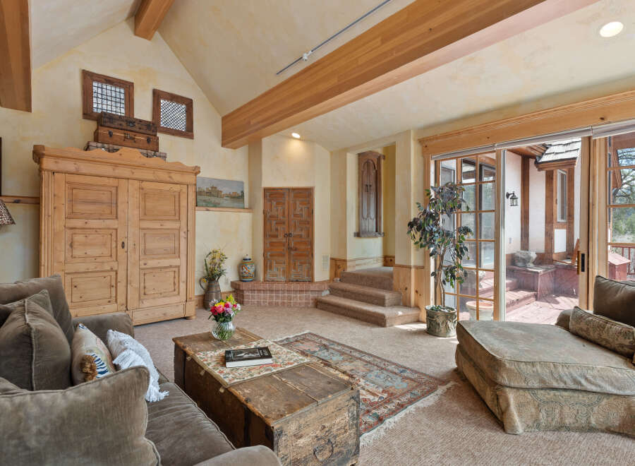 This stunning living room boasts a vaulted ceiling with exposed wooden beams, creating an open and airy atmosphere.
