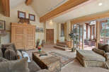 This stunning living room boasts a vaulted ceiling with exposed wooden beams, creating an open and airy atmosphere.