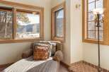 Relax and enjoy the breathtaking mountain views from this cozy chaise lounge, perfectly positioned in front of large windows.