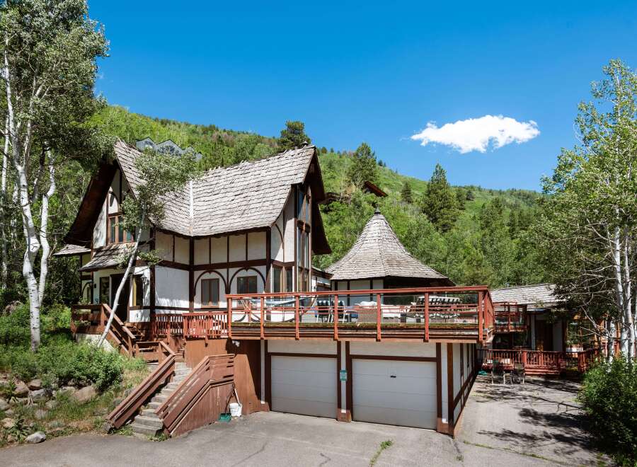 This stunning mountain home boasts a unique architectural design, featuring a charming, multi-level structure with expansive decks offering breathtaking views.