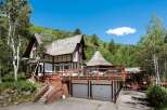 This stunning mountain home boasts a unique architectural design, featuring a charming, multi-level structure with expansive decks offering breathtaking views.